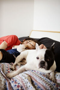 Portrait of man sleeping with daughter and dog on bed