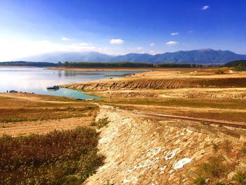 Scenic view of lake by landscape against blue sky at koprinka reservoir