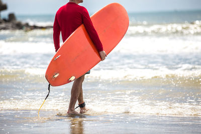 Close-up of person holding umbrella at beach