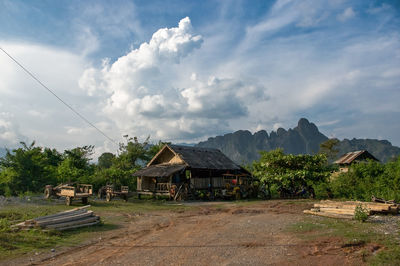 Hut on field with mountain against sky