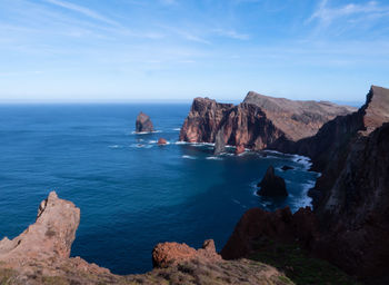 Rock formations by sea against sky