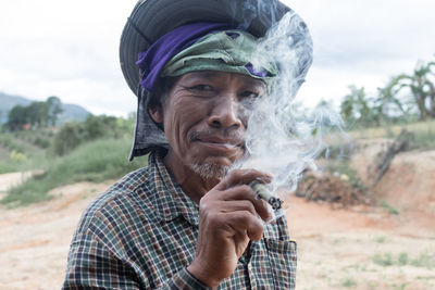 Portrait of man holding cigarette