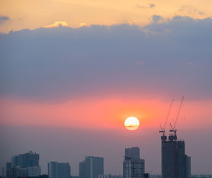 Silhouette buildings against sky during sunset