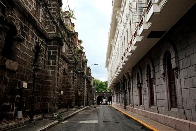 Road amidst buildings against sky