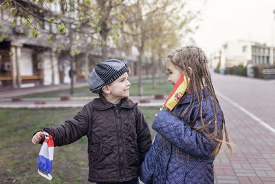 Side view of boys standing outdoors