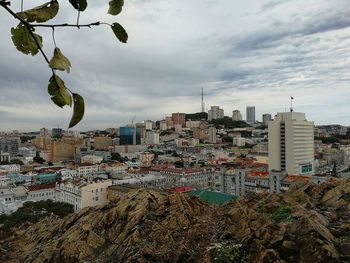 Buildings in city against cloudy sky