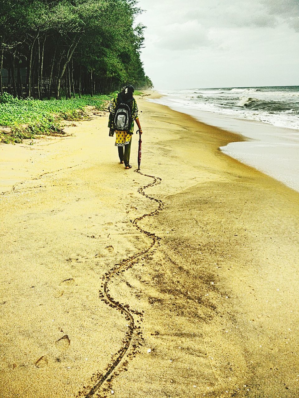 MAN ON BEACH AGAINST SEA