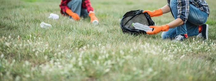 Low section of man collecting garbage from park