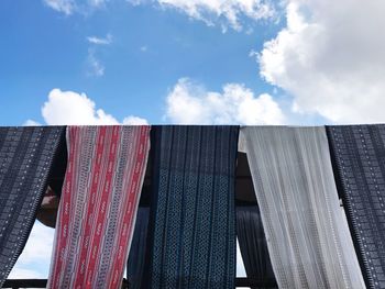 Low angle view of clothes hanging against sky