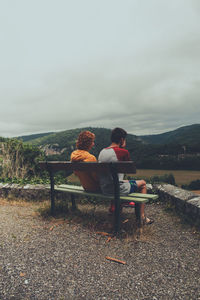 People sitting on bench looking at view