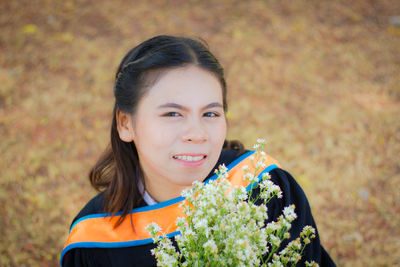 Portrait of a girl holding red flower