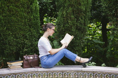 Young woman sitting on bench in park