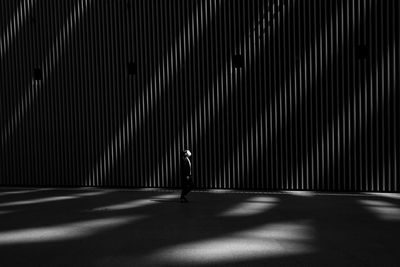 Woman standing by illuminated wall