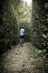 Rear view of boy running in maze