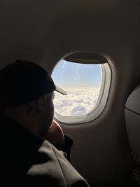 Cropped hand of man looking through window