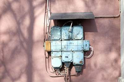 Vintage electricity circuit box, blue on a pink wall, old engineering technology. high voltage