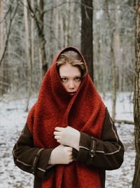 Portrait of beautiful woman standing on snow covered land