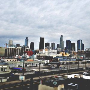 View of cityscape against cloudy sky