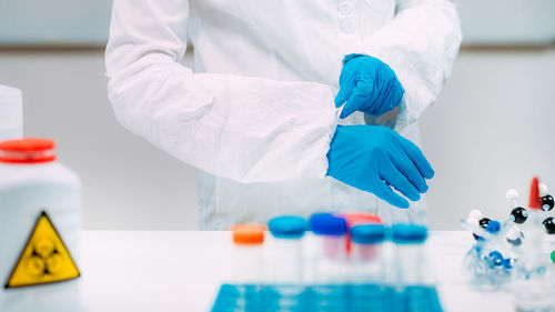 Woman putting protective splash face shield on. laboratory safety equipment.