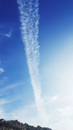 Low angle view of vapor trail against blue sky