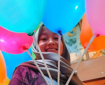 Portrait of smiling girl with multi colored balloons