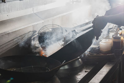 Chef stir fry busy cooking in kitchen. chef stir fry the food in a frying pan, smoke 