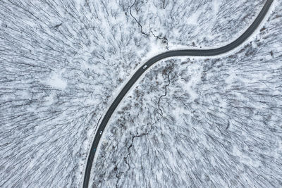 Aerial view of road amidst snow covered forest