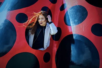 Portrait of woman peeking out from hole