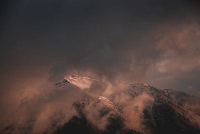 Low angle view of volcanic mountain against sky during sunset