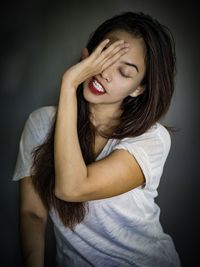 Portrait of beautiful young woman against black background