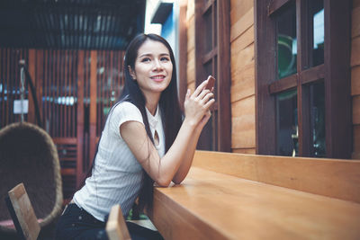 Portrait of smiling young woman standing on table