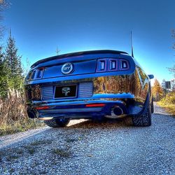 Vintage car on road against blue sky