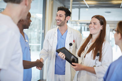 Smiling multi-ethnic healthcare team standing at lobby in hospital