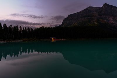 Scenic view of lake by mountains against sky