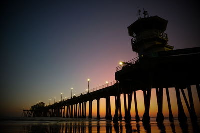 Silhouette pier by sea against sky during sunset