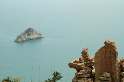 Rock formation in sea against clear sky