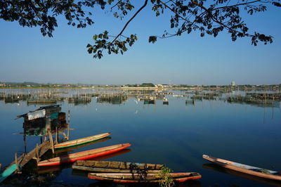 Boats moored in lake against sky