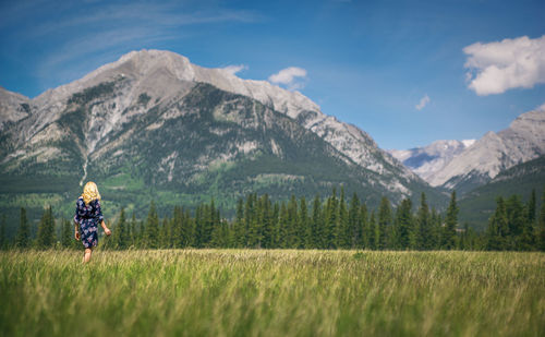 Rear view of woman on landscape against mountain range