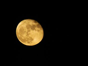 Low angle view of full moon against clear sky at night