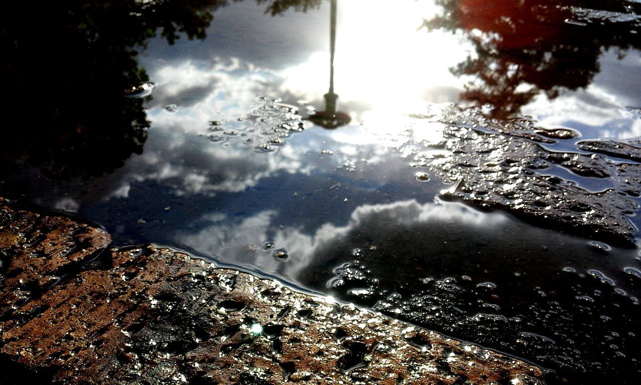 water, sky, cloud - sky, reflection, puddle, cloudy, weather, wet, rain, high angle view, nature, building exterior, cloud, river, built structure, lake, overcast, day, tree, city