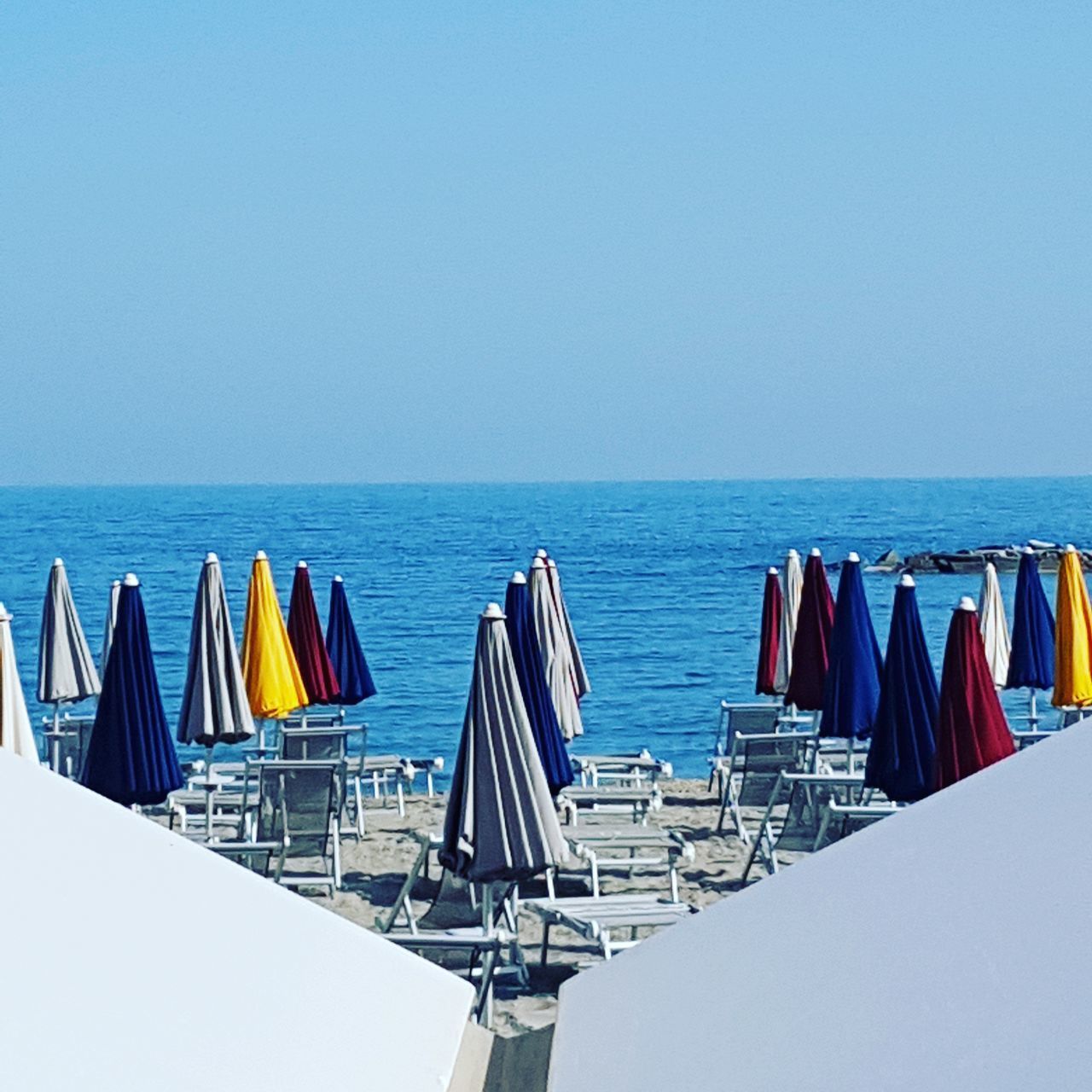 CHAIRS ON BEACH AGAINST CLEAR SKY