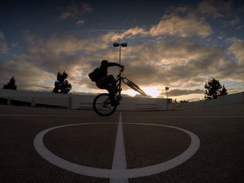 Bicycle on road against sky during sunset