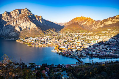 The city of lecco, shot from above, by day, with the surrounding mountains.