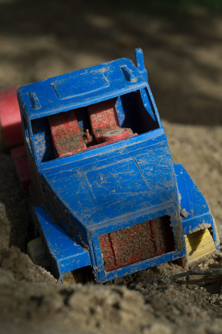 CLOSE-UP OF ABANDONED TOY ON FIELD