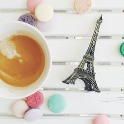 Directly above shot of coffee cup with eiffel tower figurine on table