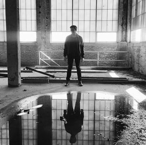 Man standing by puddle in abandoned building