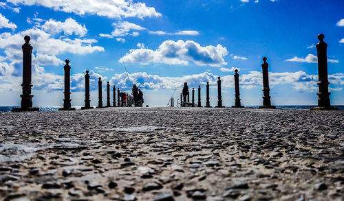 Surface level of cobblestone street against sky