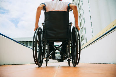 Rear view of man sitting on floor