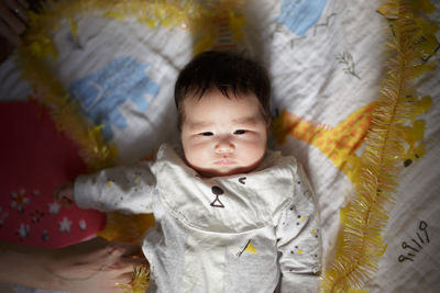 High angle view of cute baby lying on bed at home