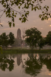 Reflection of historic building and trees on lake during sunset